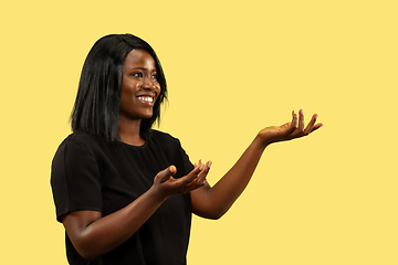 Image showing Young african woman isolated on yellow studio background, facial expression