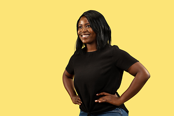 Image showing Young african woman isolated on yellow studio background, facial expression