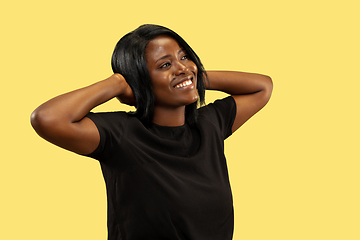 Image showing Young african woman isolated on yellow studio background, facial expression