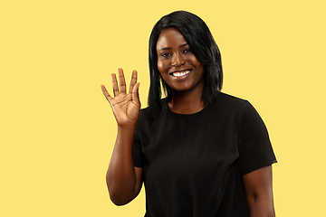 Image showing Young african woman isolated on yellow studio background, facial expression