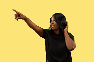 Image showing Young african woman isolated on yellow studio background, facial expression