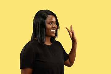 Image showing Young african woman isolated on yellow studio background, facial expression