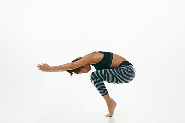 Image showing Sporty young woman doing yoga practice isolated on white background