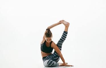 Image showing Sporty young woman doing yoga practice isolated on white background