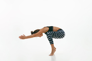 Image showing Sporty young woman doing yoga practice isolated on white background