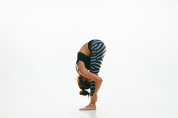 Image showing Sporty young woman doing yoga practice isolated on white background