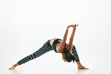 Image showing Sporty young woman doing yoga practice isolated on white background