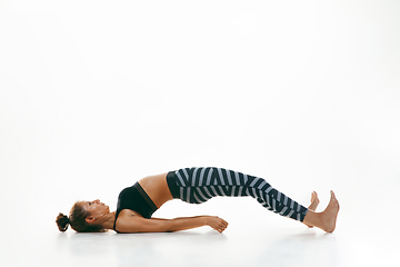 Image showing Sporty young woman doing yoga practice isolated on white background