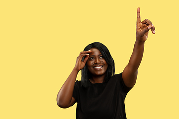 Image showing Young african woman isolated on yellow studio background, facial expression