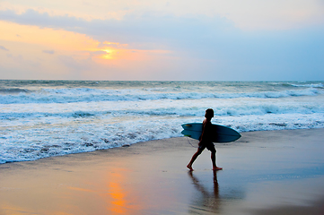 Image showing Surfer at beach with surfboard