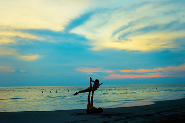 Image showing Couple practice yoga at beach 