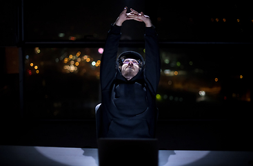 Image showing hacker using laptop computer while working in dark office