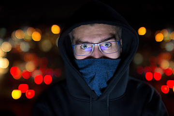 Image showing hacker using laptop computer while working in dark office