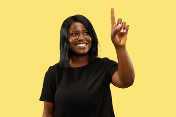 Image showing Young african woman isolated on yellow studio background, facial expression