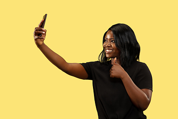 Image showing Young african woman isolated on yellow studio background, facial expression