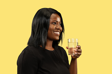 Image showing Young african woman isolated on yellow studio background, facial expression