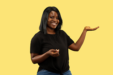 Image showing Young african woman isolated on yellow studio background, facial expression