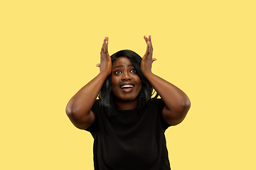 Image showing Young african woman isolated on yellow studio background, facial expression