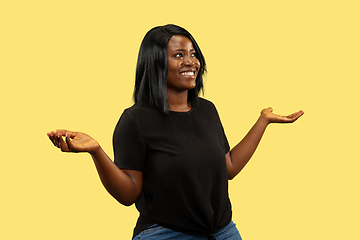 Image showing Young african woman isolated on yellow studio background, facial expression