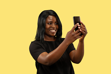 Image showing Young african woman isolated on yellow studio background, facial expression