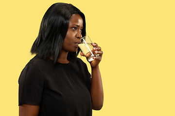 Image showing Young african woman isolated on yellow studio background, facial expression