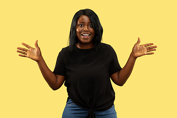 Image showing Young african woman isolated on yellow studio background, facial expression