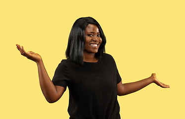 Image showing Young african woman isolated on yellow studio background, facial expression