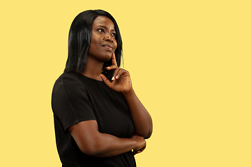 Image showing Young african woman isolated on yellow studio background, facial expression