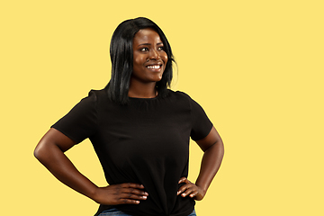 Image showing Young african woman isolated on yellow studio background, facial expression