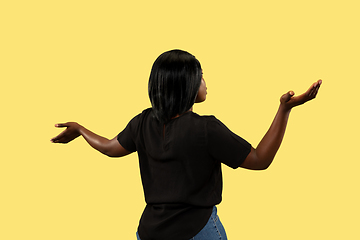 Image showing Young african woman isolated on yellow studio background, facial expression