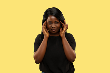 Image showing Young african woman isolated on yellow studio background, facial expression