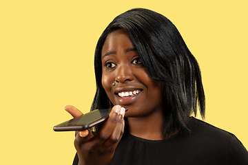 Image showing Young african woman isolated on yellow studio background, facial expression