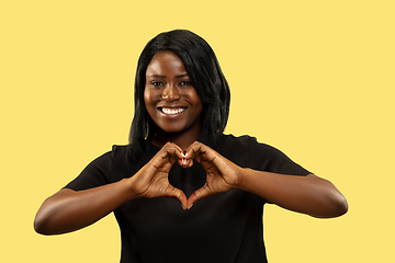 Image showing Young african woman isolated on yellow studio background, facial expression