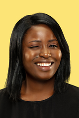 Image showing Young african woman isolated on yellow studio background, facial expression