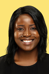 Image showing Young african woman isolated on yellow studio background, facial expression