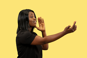 Image showing Young african woman isolated on yellow studio background, facial expression