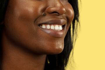 Image showing Young african woman isolated on yellow studio background, facial expression