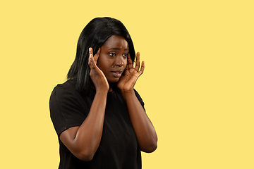 Image showing Young african woman isolated on yellow studio background, facial expression