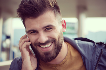 Image showing handsome young casual business man with beard using cell phone