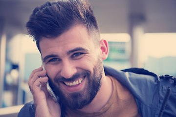 Image showing handsome young casual business man with beard using cell phone