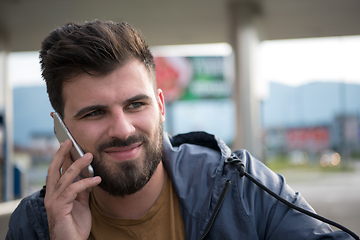 Image showing handsome young casual business man with beard using cell phone