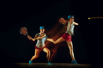 Image showing One caucasian woman playing tennis on black background in mixed light