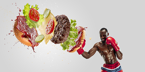 Image showing Burger\'s crashing by the boxer isolated on white background