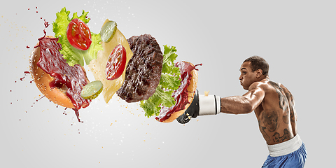 Image showing Burger\'s crashing by the boxer isolated on white background