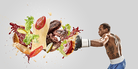Image showing Burger\'s crashing by the boxer isolated on white background