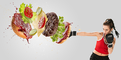 Image showing Burger\'s crashing by the boxer isolated on white background