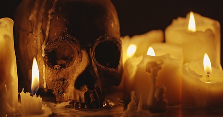 Image showing Candles and human skull in darkness closeup footage