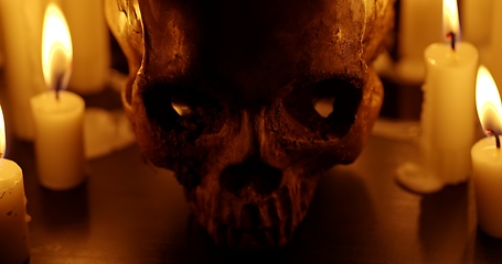 Image showing Candles and human skull in darkness closeup footage