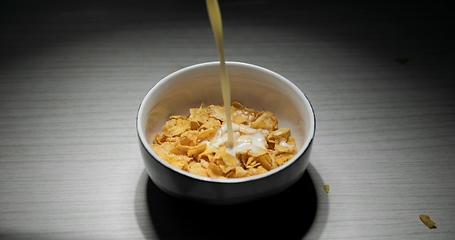 Image showing Pouring milk into bowl of cereal closeup