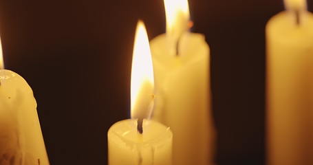 Image showing Candles glowing against dark background